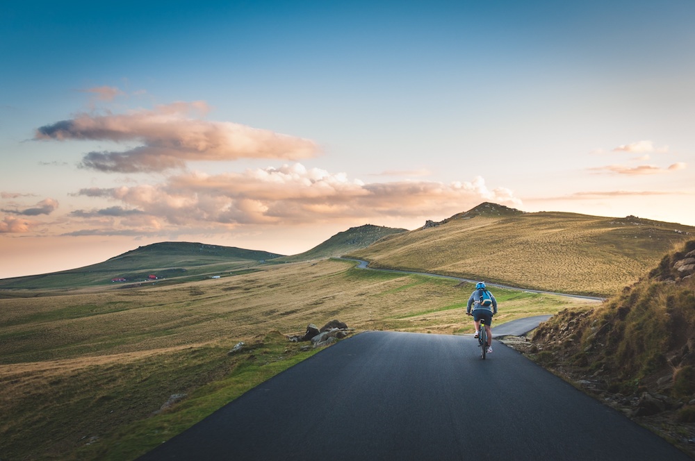 Male rider on the road, green hills in the background